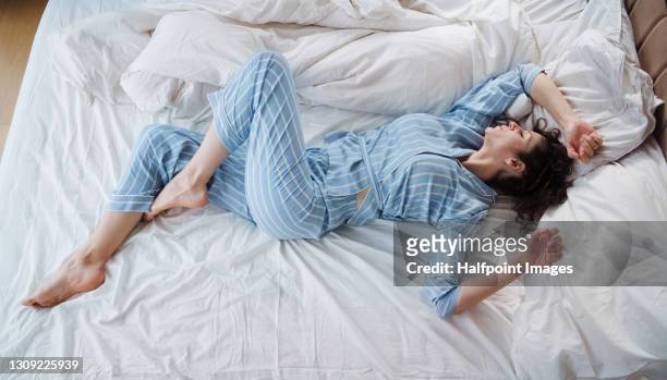 top view of woman in pajamas sleeping in bed in bedroom. - pajamas stockfoto's en -beelden