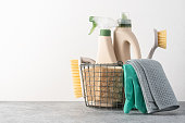 Brushes, sponges, rubber gloves and natural cleaning products in the basket