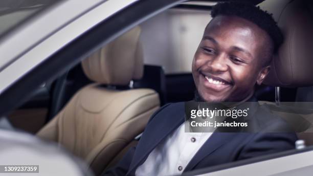 african businessman enjoying first ride in new car. - man driving sports car stock pictures, royalty-free photos & images