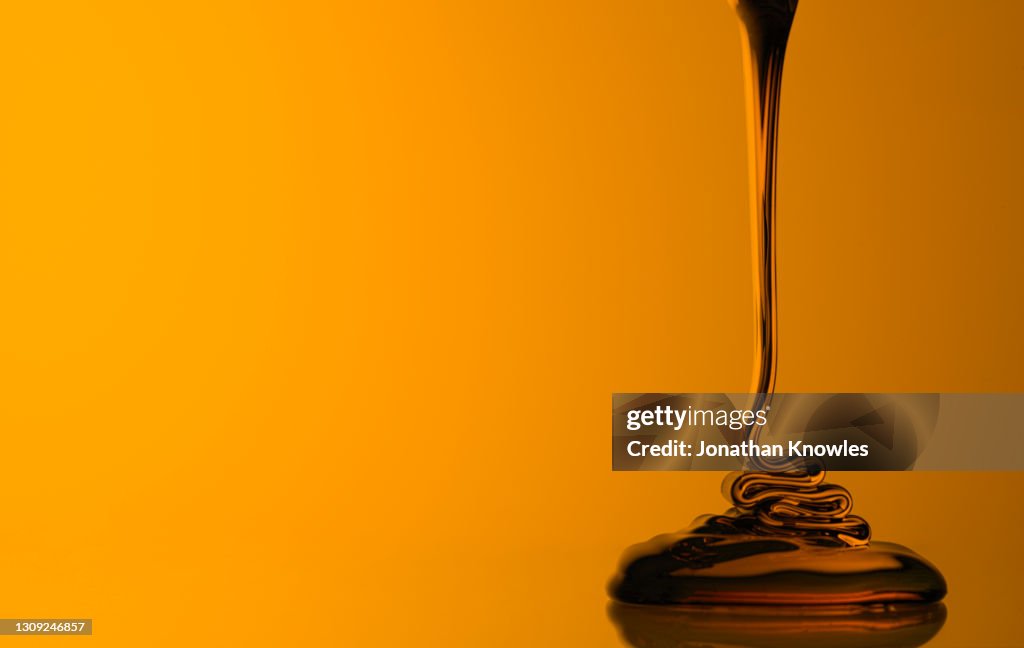 Honey pour on yellow background