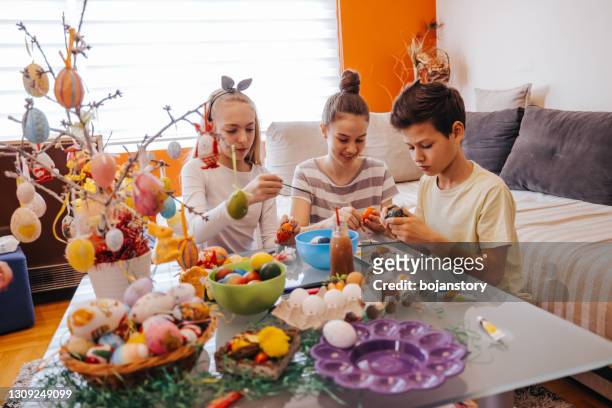 kids painting easter eggs at home - easter basket stock pictures, royalty-free photos & images