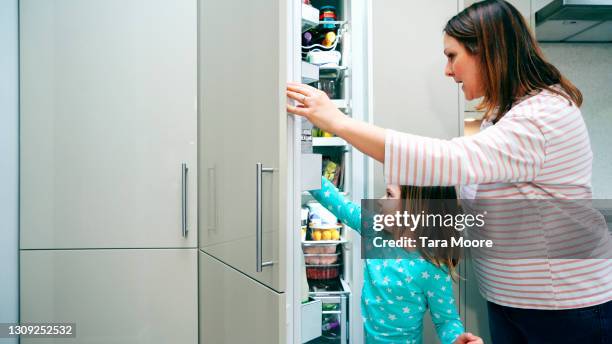 mother and daughter looking in fridge - open day 6 fotografías e imágenes de stock