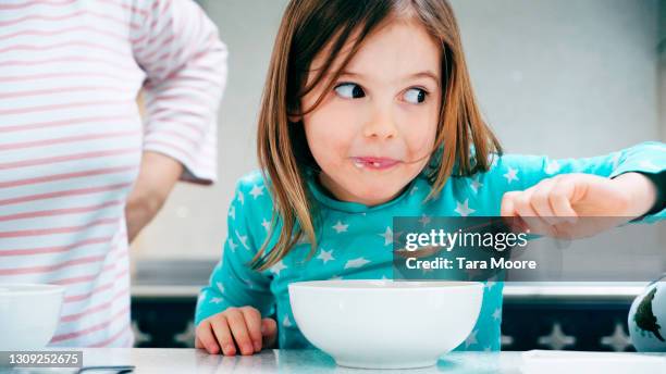 young girl eating breakfast - blue bowl stock-fotos und bilder