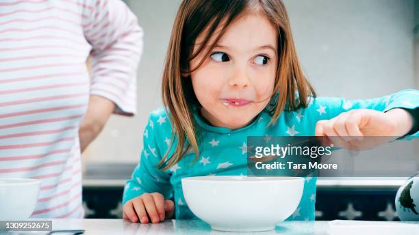 young girl eating breakfast - blue bowl stockfoto's en -beelden
