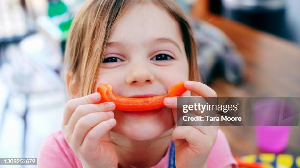 young girl smiling with pepper - peper groente stockfoto's en -beelden