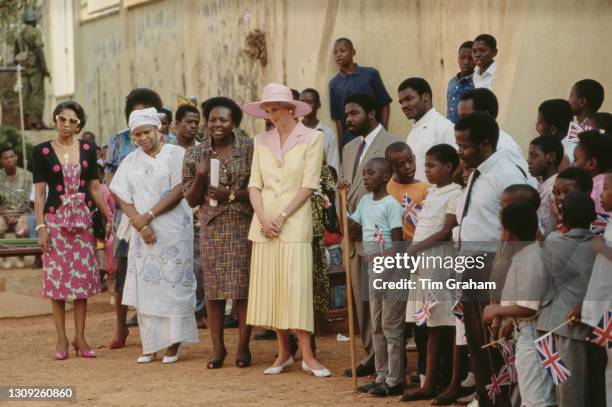 British Royal Diana, Princess of Wales , wearing a pink and yellow Catherine Walker suit with a hat designed by Philip Somerville, visits a school...