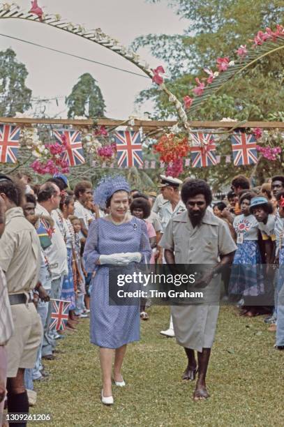 British Royal Queen Elizabeth II, wearing a blue polka dot dress and a blue hat by Frederick Fox, and Prince Philip, Duke of Edinburgh attend a...