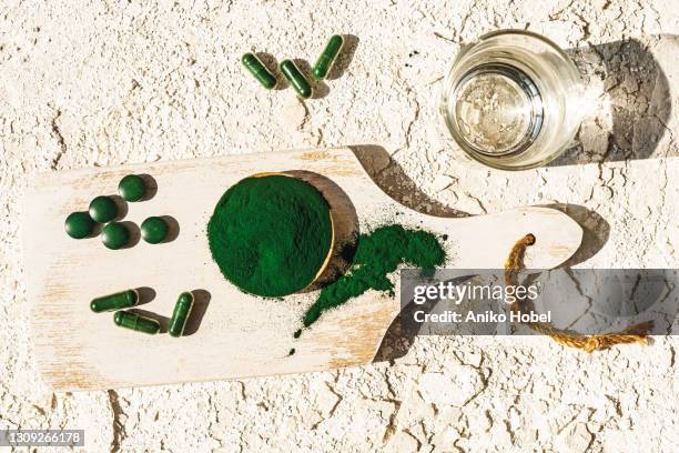 green algae powder, pills and capsules - wheatgrass stock pictures, royalty-free photos & images