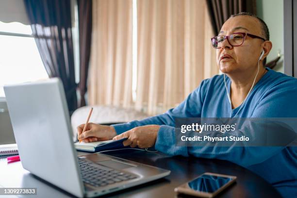 seniorin arbeitet zu hause am laptop - cellphone cancer illness stock-fotos und bilder