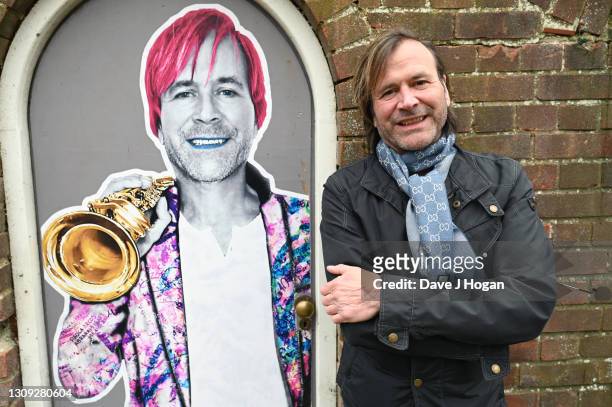 Steve Norman stands alongside a commissioned art piece by "Postman Art" street artists to celebrate his 61st birthday on March 26, 2021 in Brighton,...
