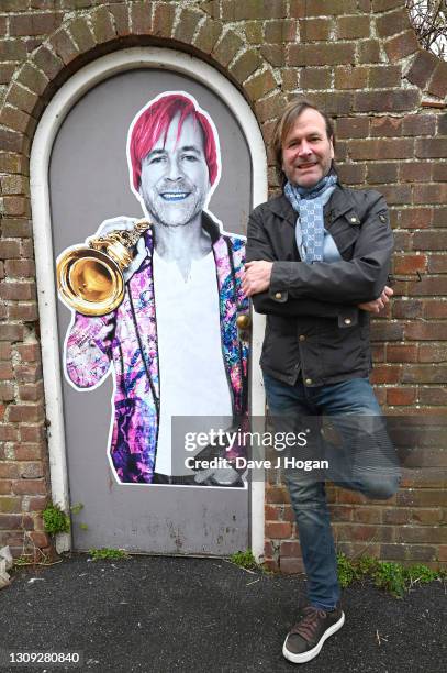 Steve Norman stands alongside a commissioned art piece by "Postman Art" street artists to celebrate his 61st birthday on March 26, 2021 in Brighton,...