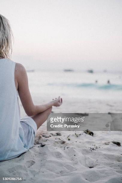 meditierende frau am strand - mindfulness stock-fotos und bilder