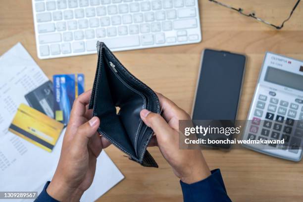 close up man hand opening empty wallet over calculator. - bolsa preta imagens e fotografias de stock