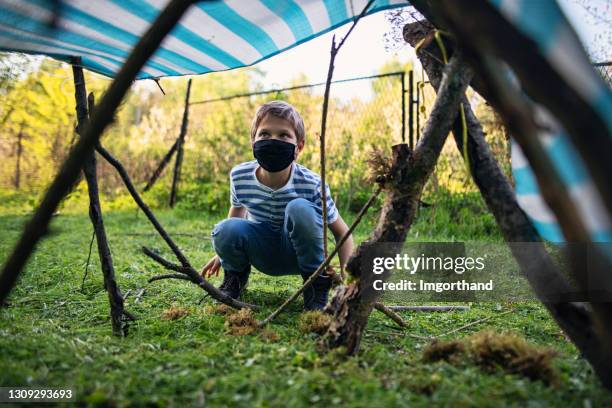 little boy stick shelter in autumn forest - makeshift shelter stock pictures, royalty-free photos & images