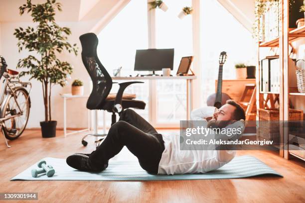 zakenman die onderbreking neemt om in huisbureau uit te werken - sit ups stockfoto's en -beelden