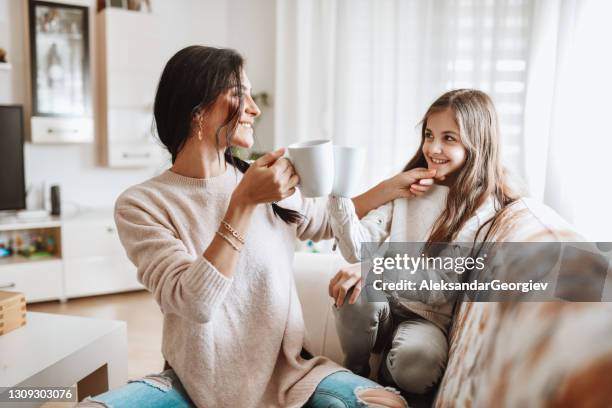 hot drink time for mother and daughter at home - drinking tea in a cup stock pictures, royalty-free photos & images