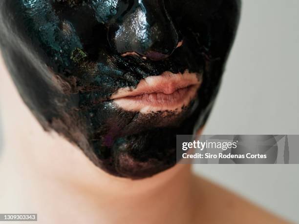 woman with charcoal mask puckering lips - blackheads photos et images de collection