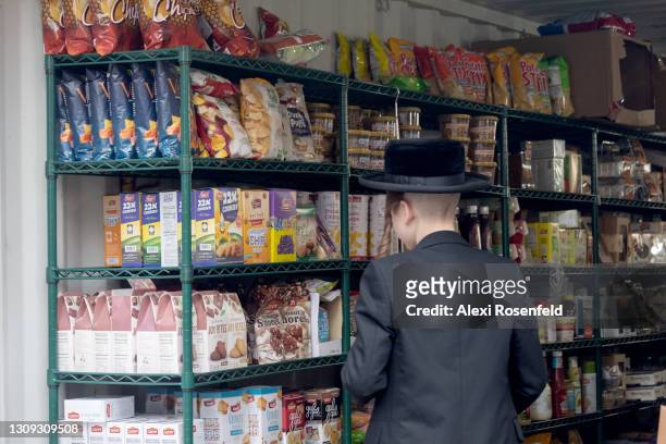 An Ultra-Orthodox Jewish person buys kosher for passover groceries at an outdoor supermarket amid the coronavirus pandemic in Williamsburg on March...