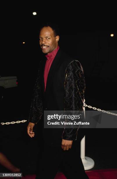 American actor and comedian Keenen Ivory Wayans, wearing a red shirt beneath a black jacket, which has sleeves decorated with gold thread, location...