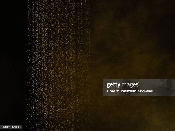 water shower - gold and black background stock pictures, royalty-free photos & images