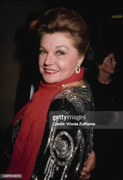 American swimmer and actress Esther Williams , wearing a black-and-silver outfit with a red scarf, attends the 7th Annual American Cinema Awards,...