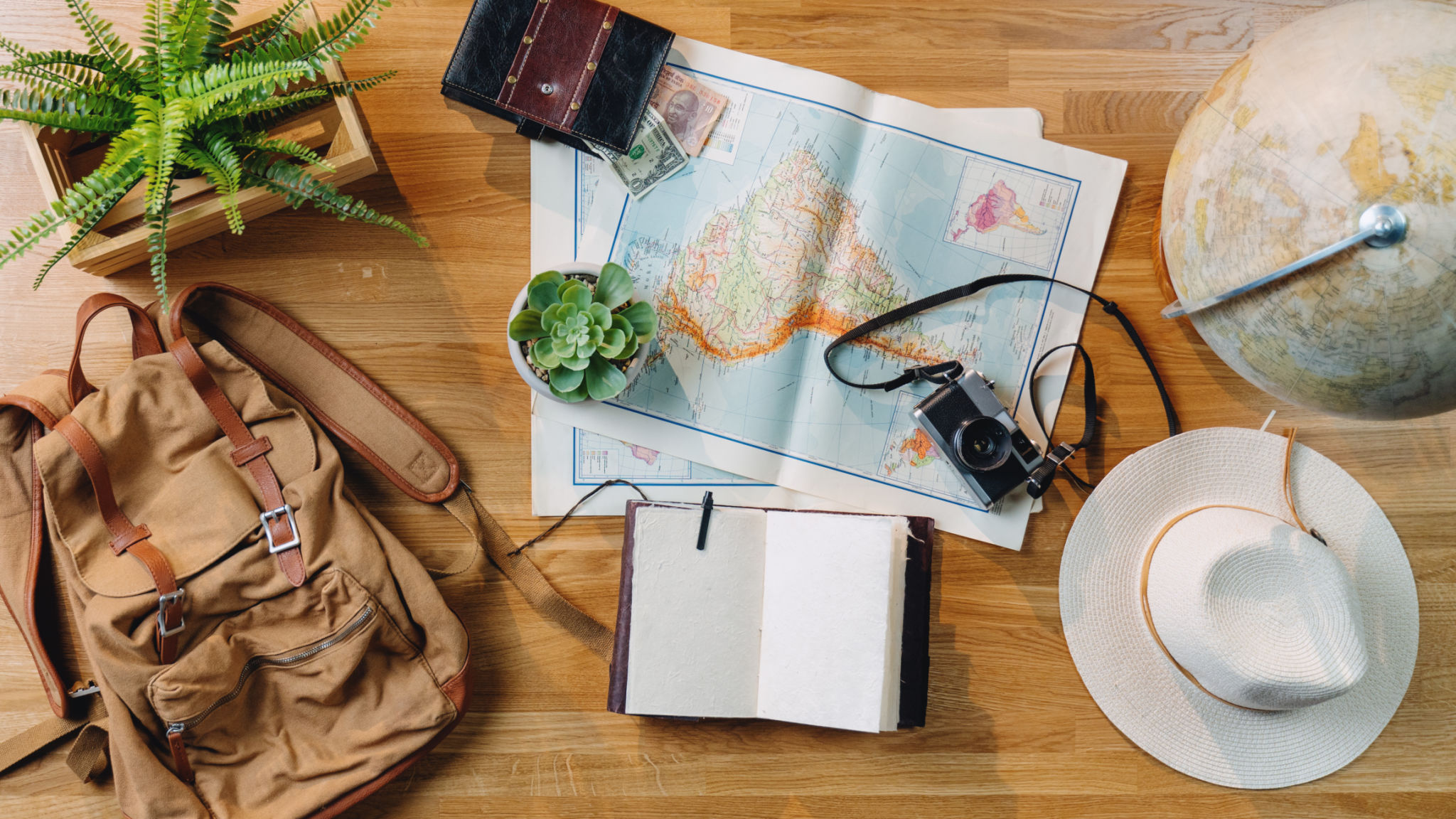 Concepto de viaje de escritorio con vista superior plana, computadora portátil, mapas y otros elementos esenciales de viaje. Concepto de viaje de escritorio con vista superior plana, computadora portátil, mapas y otros elementos esenciales de viaje.