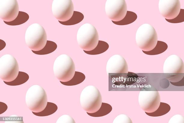 trendy pattern made of white easter egg on pastel pink background. - easter pattern stockfoto's en -beelden