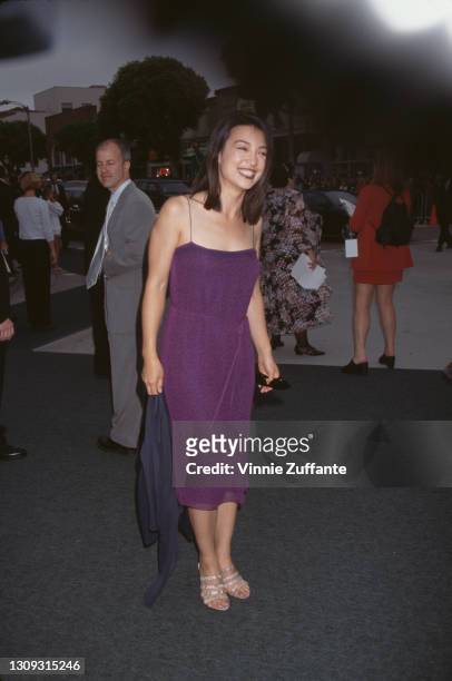 Chinese-American actress Ming-Na Wen, wearing a purple dress with spaghetti straps, attends the premiere of 'Saving Private Ryan', held at the Mann...