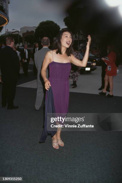 Chinese-American actress Ming-Na Wen, wearing a purple dress with spaghetti straps, attends the premiere of 'Saving Private Ryan', held at the Mann...