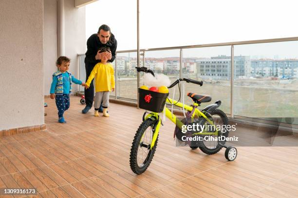 der vater gibt seinem sohn das von ihm gekaufte geschenkfahrrad. - two kids with cycle stock-fotos und bilder