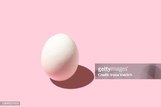 trendy pattern made of white easter egg on pastel pink background. - easter egg stock pictures, royalty-free photos & images