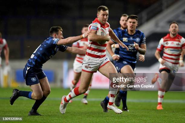 Iain Thronley of Leigh Centurions is challenged by Harry Smith of Wigan Warriors during the Betfred Super League match between Leigh Centurions and...