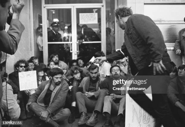 Police squad wedged through a line of 2,500 anti-draft pickets to arrest this group staging a sit-in at the entrance to the Oakland Induction center....
