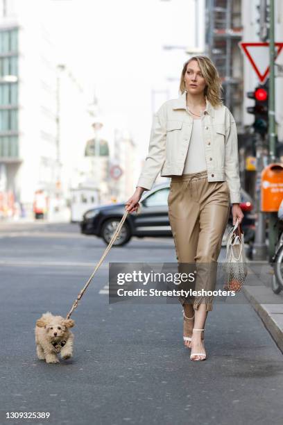 German model and actress Victoria Jancke wearing light brown leather pants by Marc Cain, a cream colored top by Marc Cain, a cream colored denim...