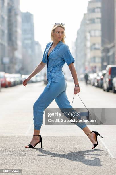 German model and actress Victoria Jancke wearing a light blue denim jeans jumpsuit by Guess, a blue and white bag by Picard, sunglasses by Prada, a...