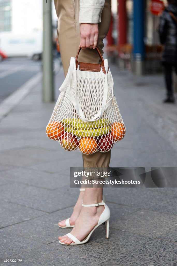 A fabric net bag by Longchamp and cream colored sandals by Aldo Shoes  News Photo - Getty Images