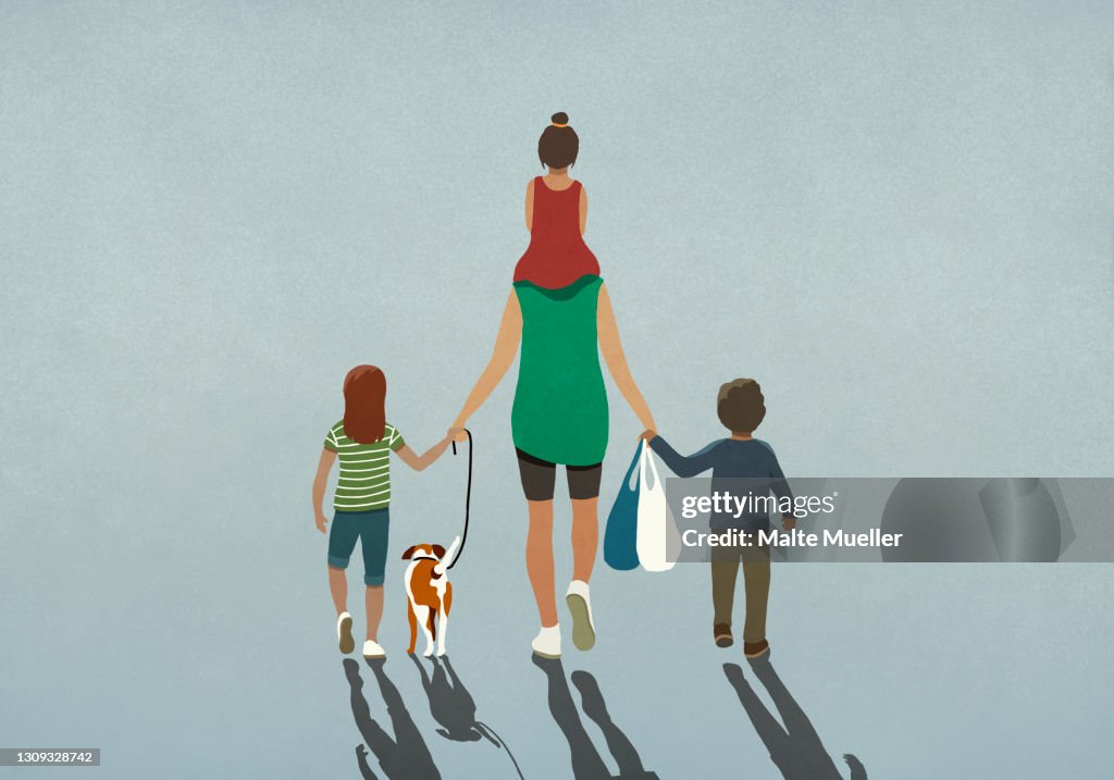 Family with dog holding hands and walking with grocery bags