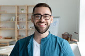 Headshot portrait of smiling male employee in office