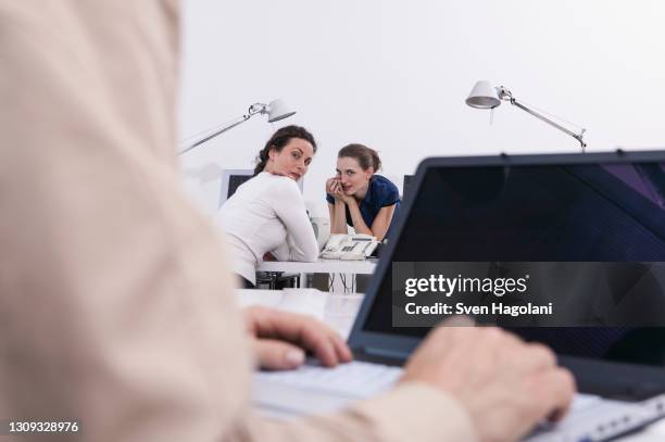 businesswomen gossiping about colleague in office - bavardage photos et images de collection