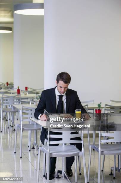 businessman looking down at lunch tray in office cafeteria - workplace canteen lunch stock pictures, royalty-free photos & images