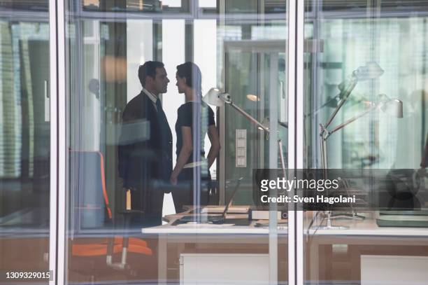 businessman and businesswoman face to face in office - harassment man woman office stock-fotos und bilder