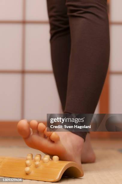 close up young barefoot woman using foot massager in spa - sven hagolani stock pictures, royalty-free photos & images