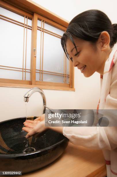 young woman washing hands at spa sink - sven hagolani stock pictures, royalty-free photos & images