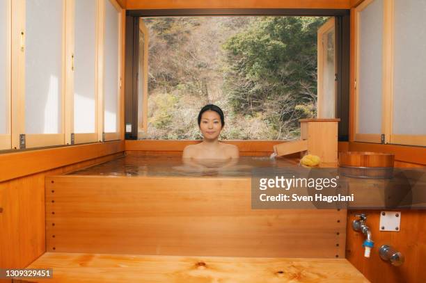 portrait beautiful young woman soaking in pool at japanese onsen - sven hagolani stock-fotos und bilder