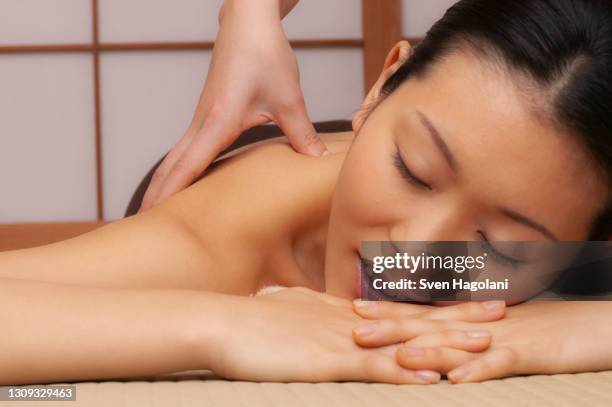 close up beautiful serene young woman receiving massage at spa - sven hagolani stock-fotos und bilder