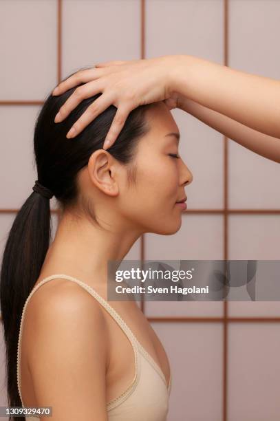 serene young woman receiving scalp massage at spa - cuero cabelludo fotografías e imágenes de stock