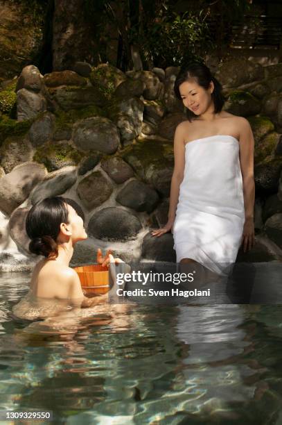 young women friends relaxing at onsen pool - sven hagolani stock-fotos und bilder