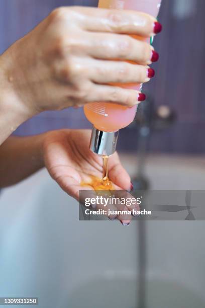 close-up of a female hand holding a shampoo/soap. - shampoo imagens e fotografias de stock