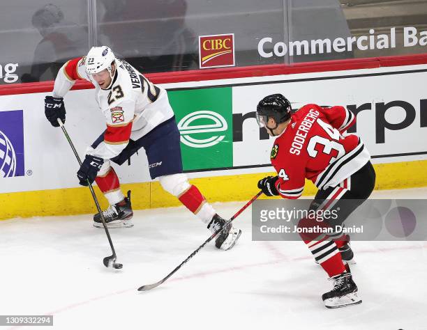 Carter Verhaeghe of the Florida Panthers controls the puck against Carl Soderberg of the Chicago Blackhawks at the United Center on March 25, 2021 in...