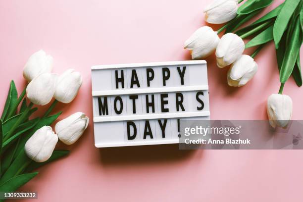 greeting card for spring holidays, white tulip flowers over pink background with copy space. template for mother's day. floral picture. - happy mothers day fotografías e imágenes de stock